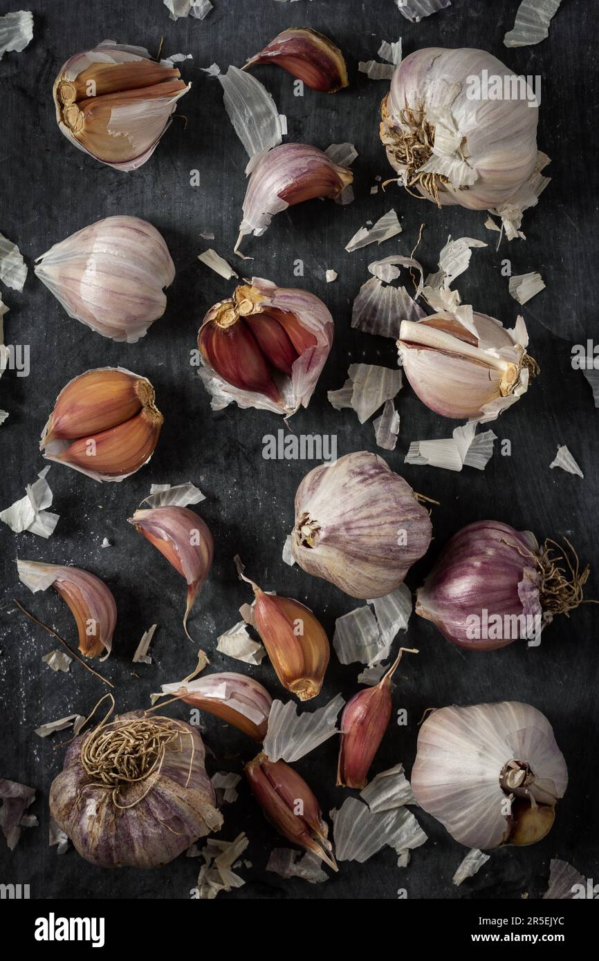 Fresh garlic bulbs and cloves grouped on black background. Flat lay ...