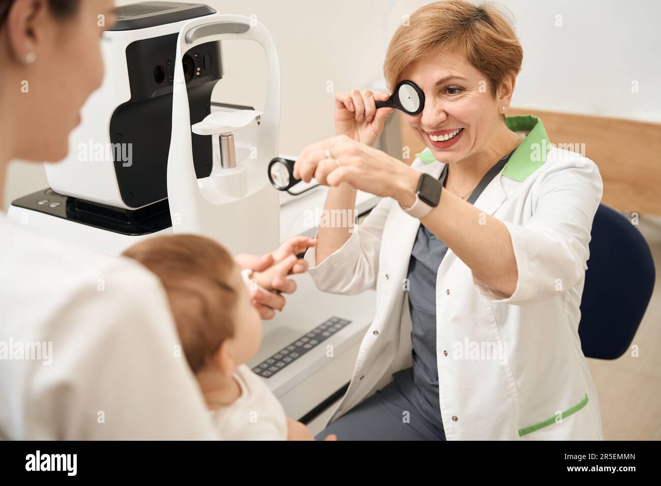 Ophthalmic professional entertaining little patient during primary