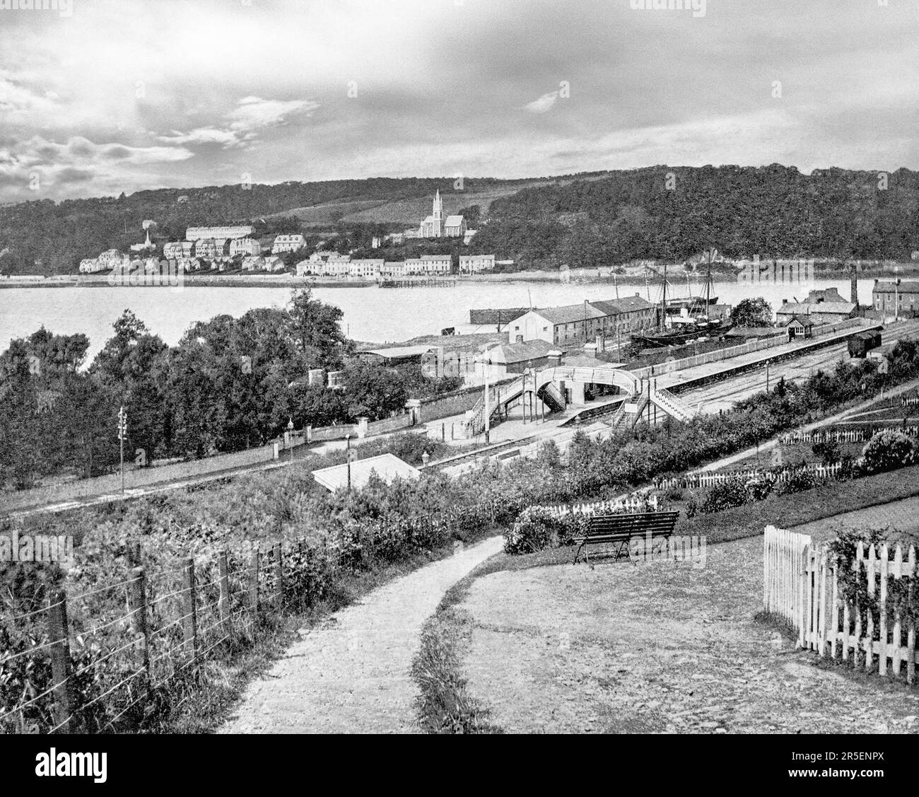A late 19th century view of the waterfront and railway station in Monkstown, a village in County Cork, Ireland. It lies on the estuary of the River Lee, facing Great Island and looking onto Monkstown Bay. The name of the village is said to derive from an early monastic site near to where Monkstown Castle now stands, altough no archaeological evidence remains for the monastery. Stock Photo