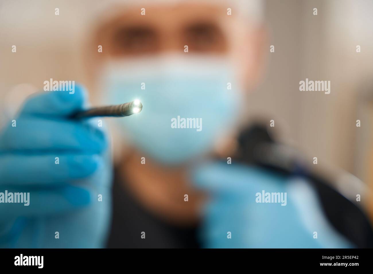 Endoscopist in face mask and nitrile gloves using endoscopy instrument Stock Photo