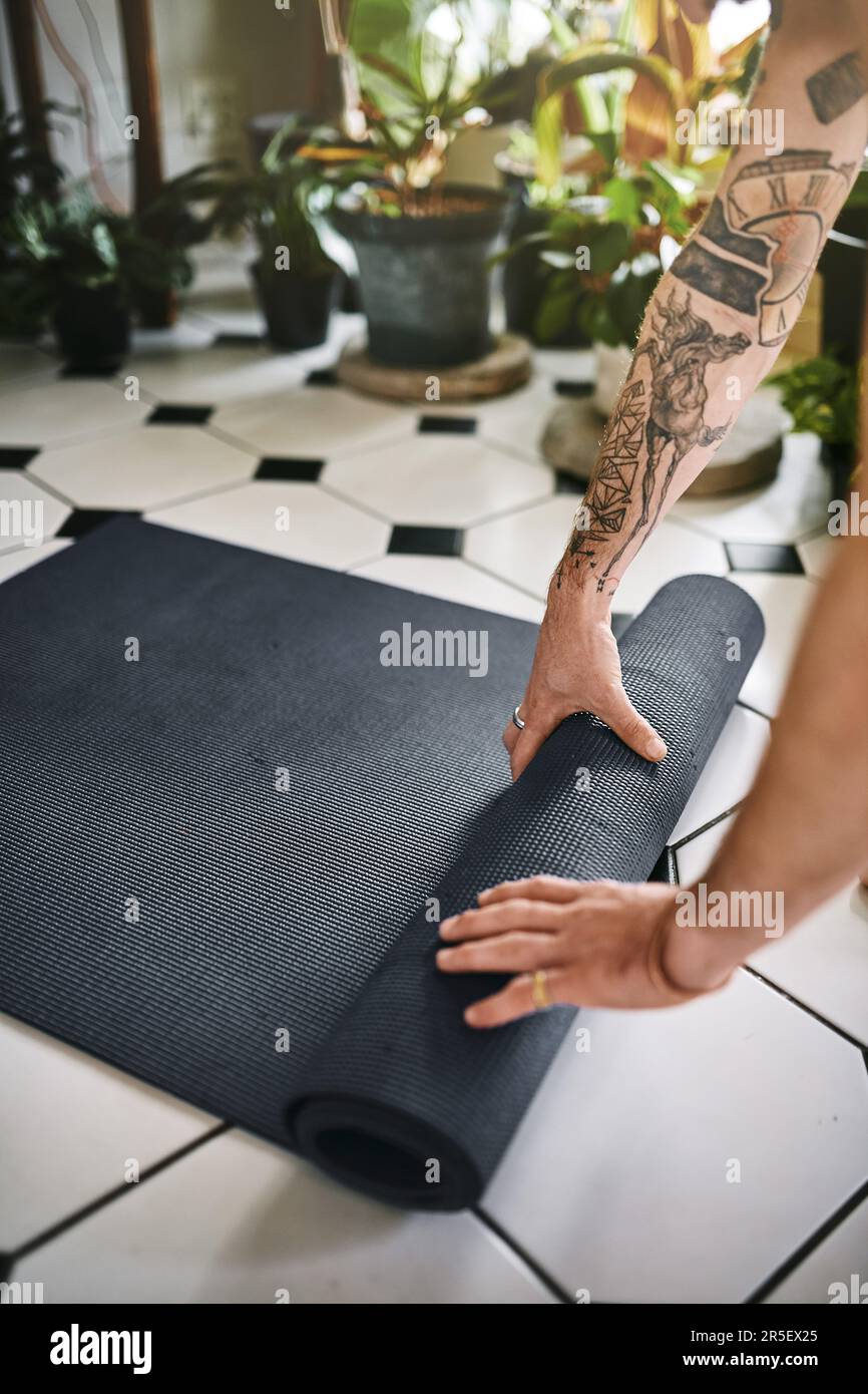 All you should bring to a session is good intention. an unrecognisable man rolling up his yoga