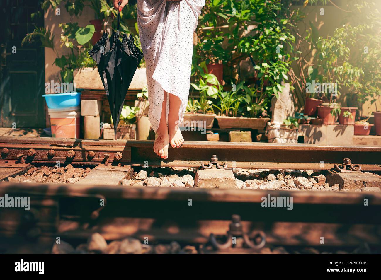 Feet were made for exploring. a woman walking barefoot on train tracks