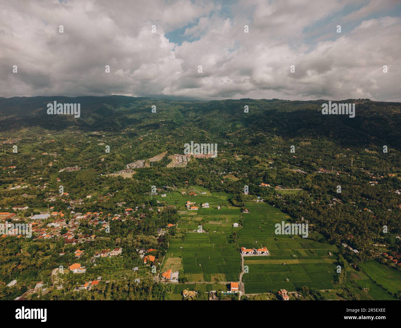 Aerial view of green valley with rolling hills, trees, and houses ...