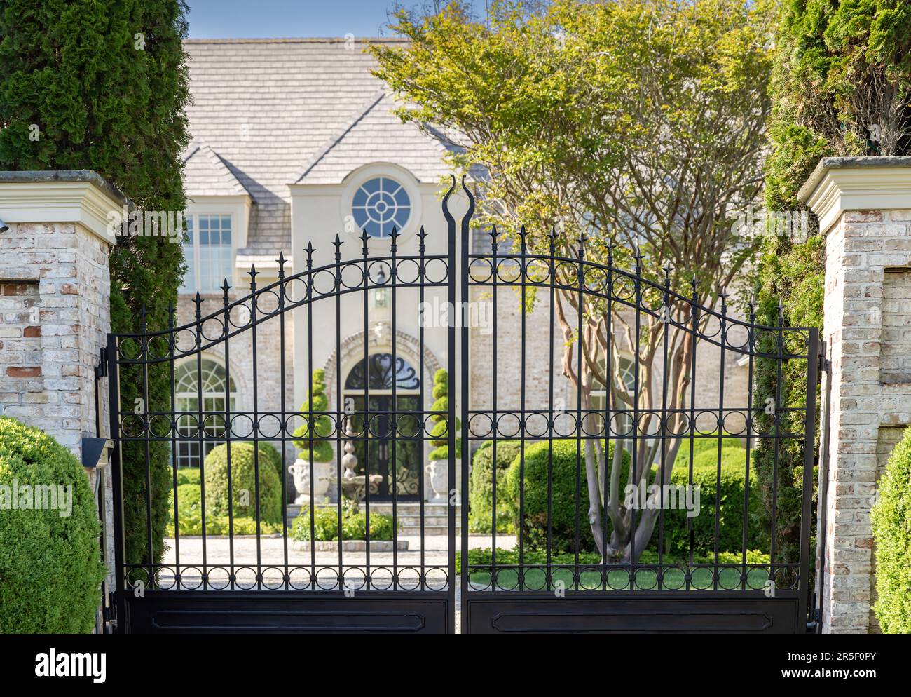 looking through black wrought iron gates at a southampton mansion Stock Photo Alamy