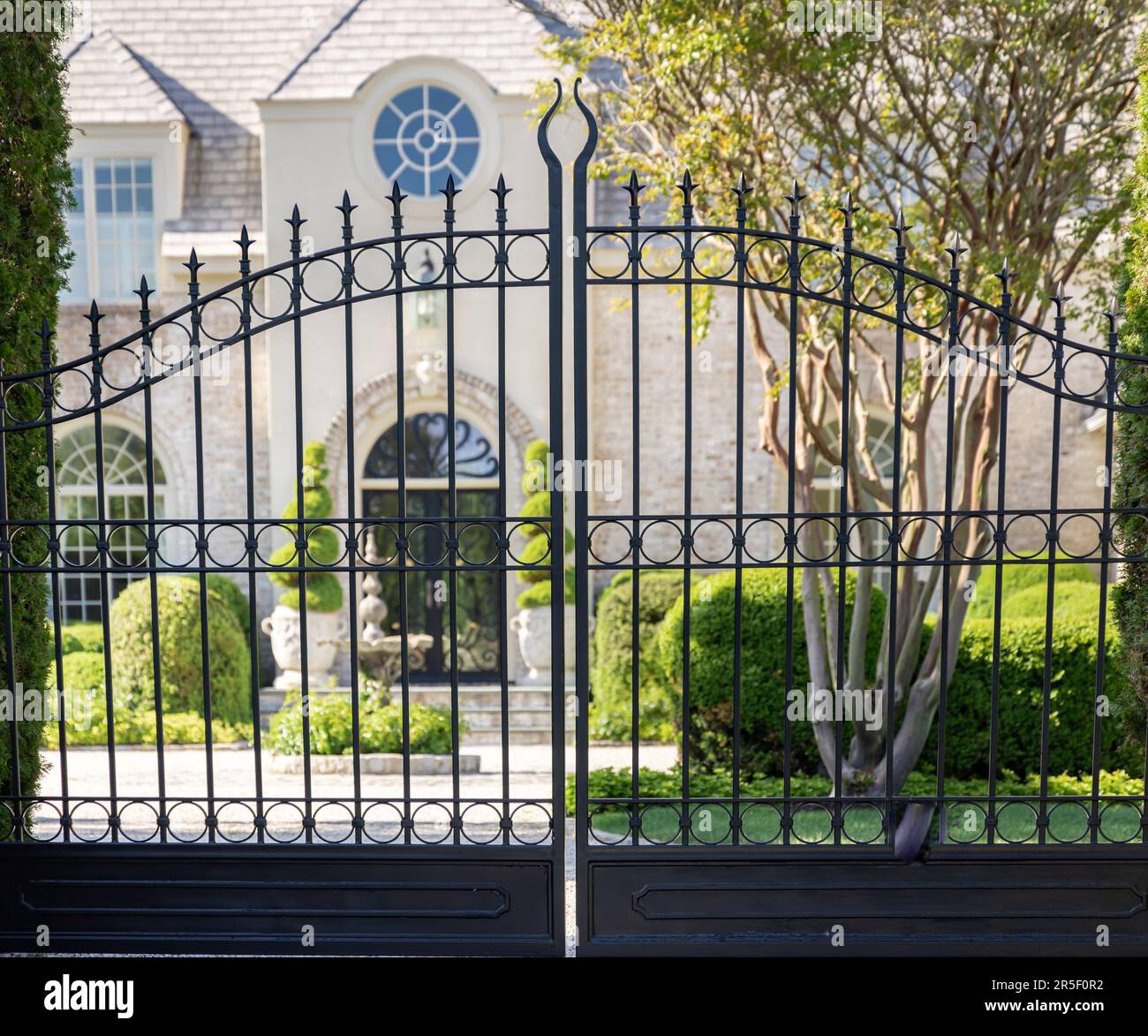 looking through black wrought iron gates at a southampton mansion Stock Photo Alamy