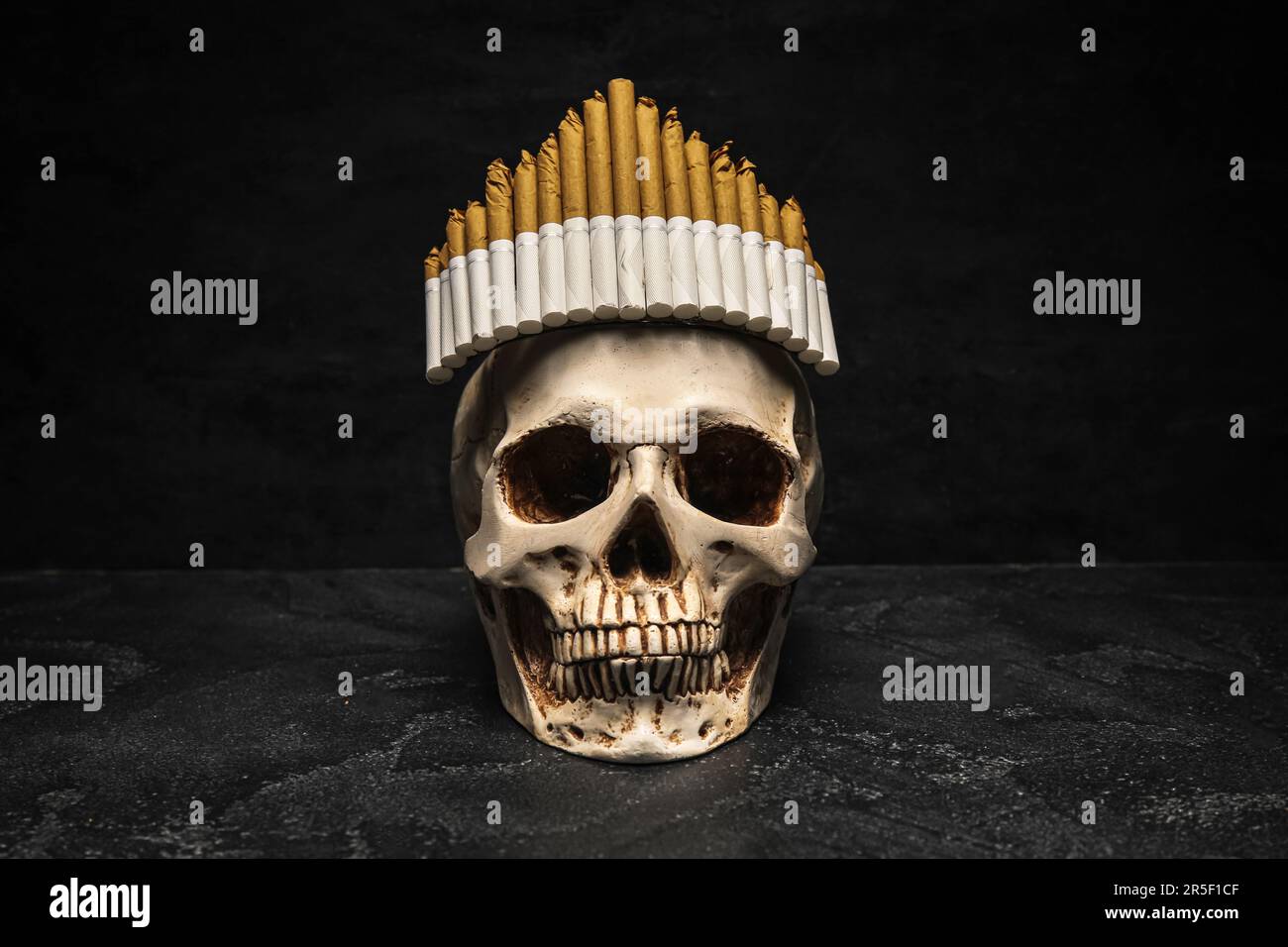 Human scull with crown made of cigarettes on dark background. Stop smoking  concept Stock Photo