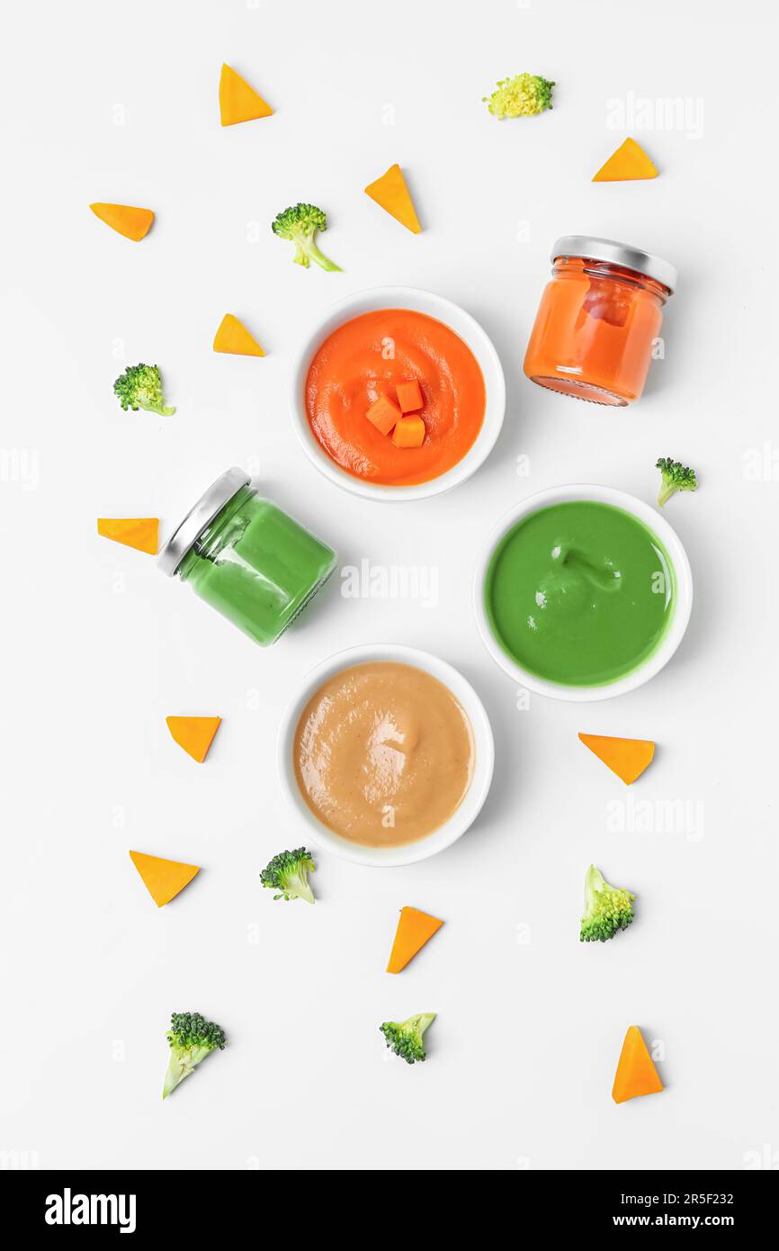 Composition with healthy baby puree and cut vegetables on white