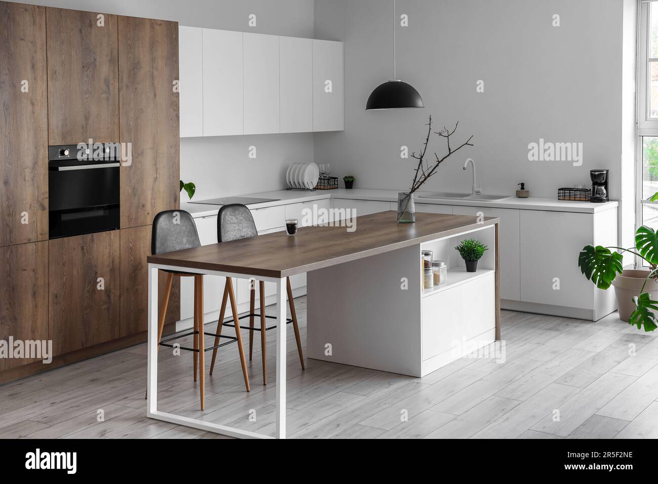 Interior of modern kitchen with island, built-in oven and white ...
