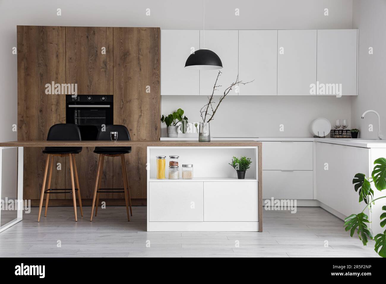 Interior of modern kitchen with island, built-in oven and white ...