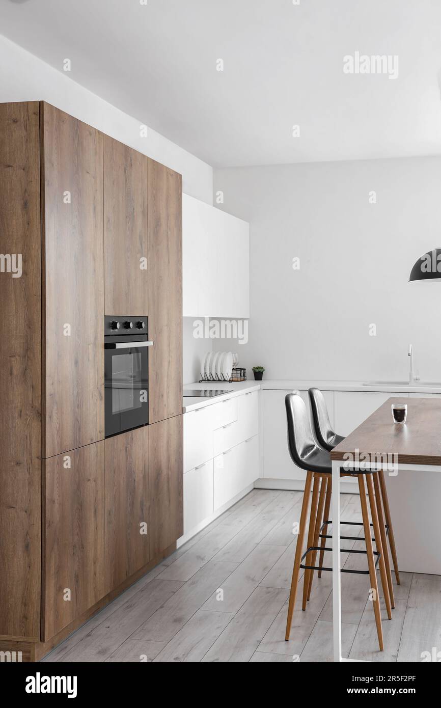 Interior of modern kitchen with island, built-in oven and white ...