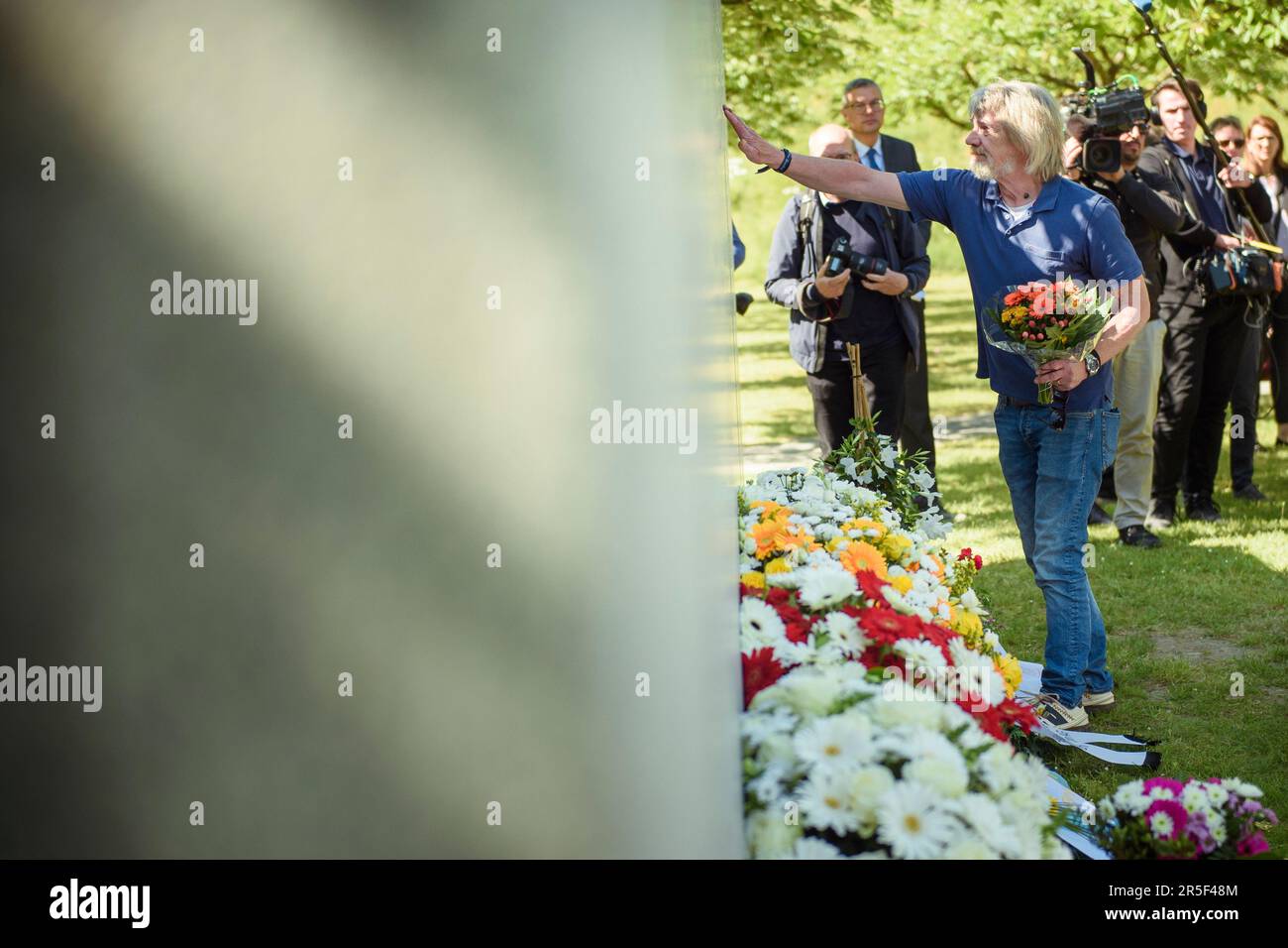 Eschede, Germany. 03rd June, 2023. A man lays flowers and touches the memorial stone at the 25th anniversary memorial for victims of the Eschede ICE accident. On June 03, 1998, after a wheel tire broke in Eschede, Lower Saxony, several rail cars of an ICE train crashed into a road bridge at a speed of 200. 101 people died. Credit: Gregor Fischer/dpa/Alamy Live News Stock Photo