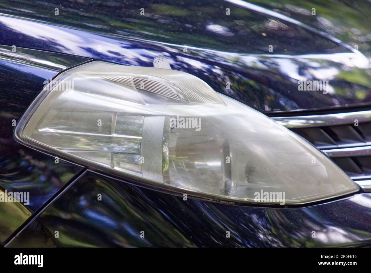 Front light of a black car Auto head light with yellowing Stock Photo