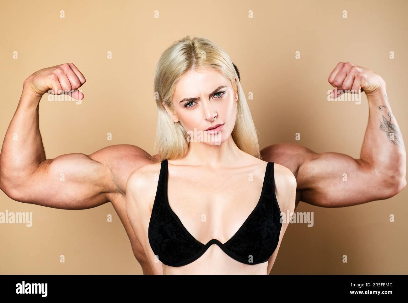 Funny fitness couple. Funky girl have bodybuilding practice, show biceps. A  young female model posing with male big muscles. Fun fitness. Woman power  Stock Photo - Alamy