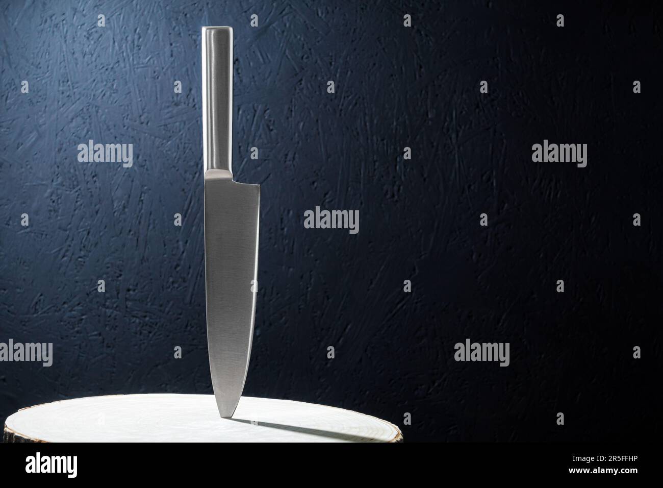 A professional kitchen knife, a knife stuck in wood. Closeup of a