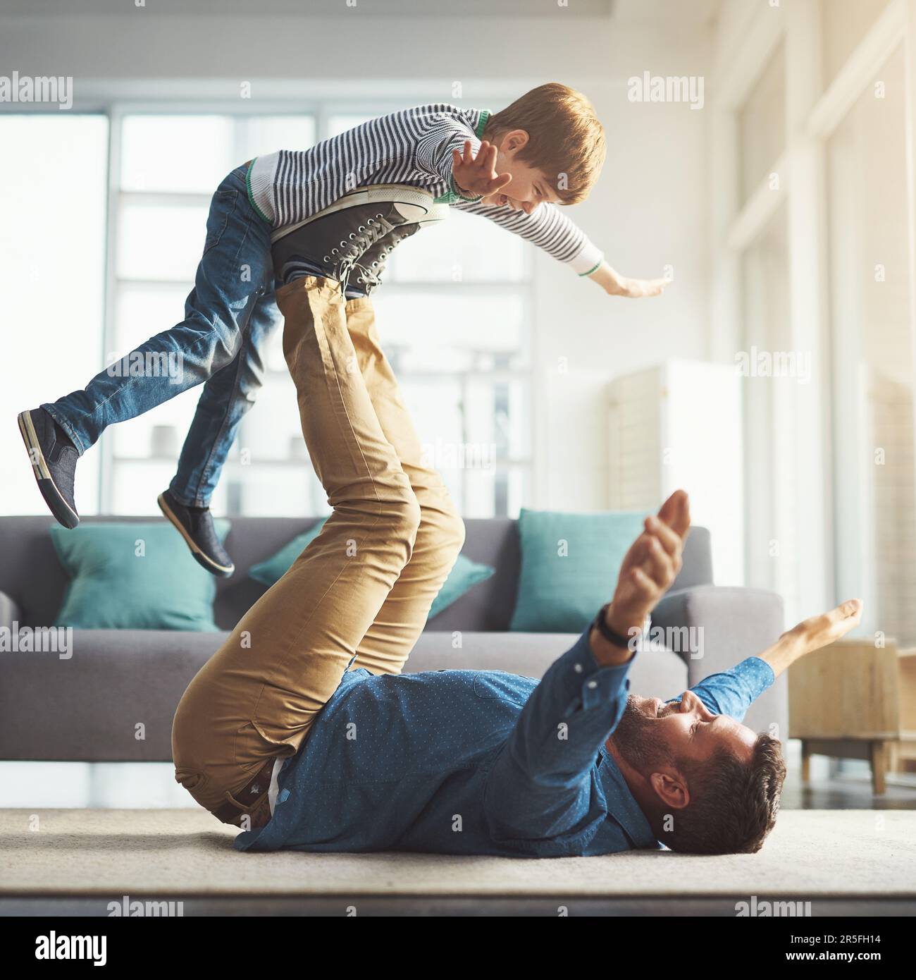 Raising up higher and higher. a cheerful little boy playing around and ...