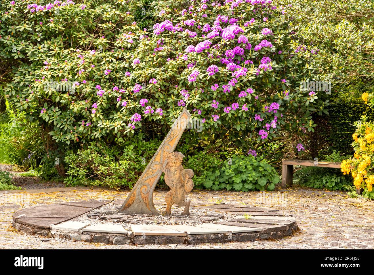 Attadale Gardens Wester Ross Scotland purple rhododenron flowers surround the clock with gnomon and wild cat Stock Photo