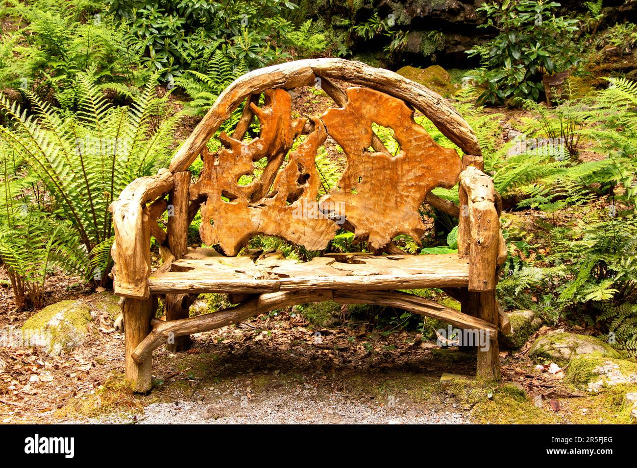 Attadale Gardens Wester Ross Scotland the gardens in Spring and a large carved wooden seat Stock Photo