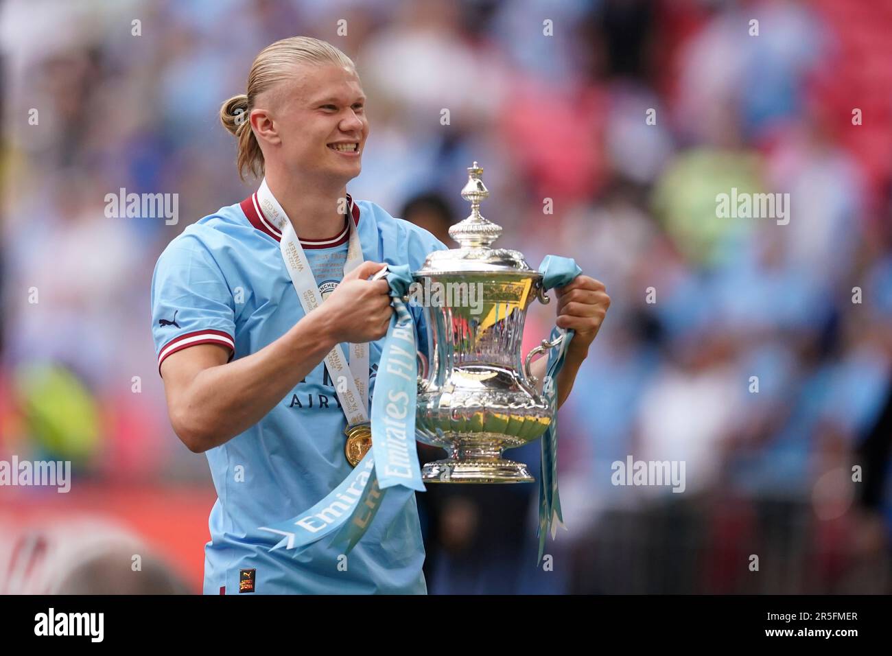 Manchester City's Erling Haaland holds the winners trophy as he celebrates  winning the English FA Cup final soccer match between Manchester City and  Manchester United at Wembley Stadium in London, Saturday, June