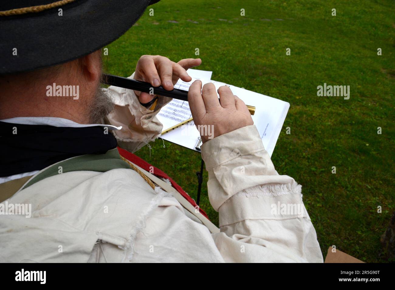 A musician dressed in 18th century style clothing plays a fife at a living history reenactment event in Abingdon, Virginia. See additional info Stock Photo