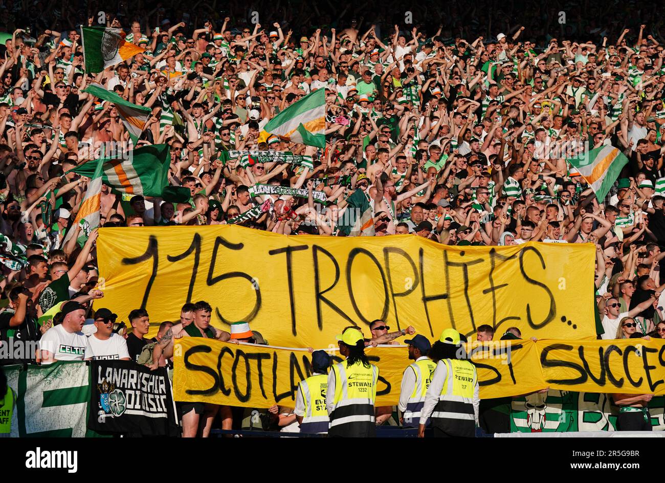 Celtic fans in the stands display a banner saying '115 trophies' during