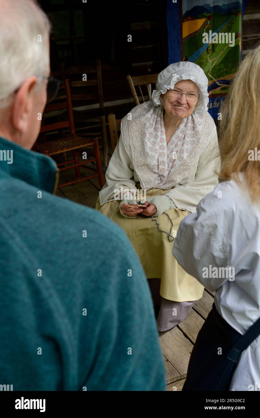 A 19th century pioneer reenactor talks with visitors while