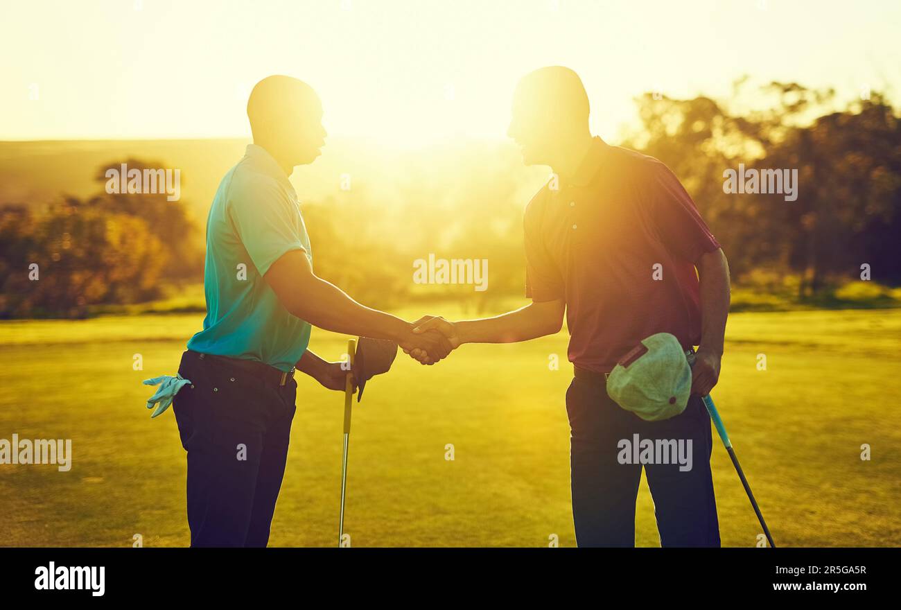 Best of luck buddy. two golfers shaking hands on the golf course Stock