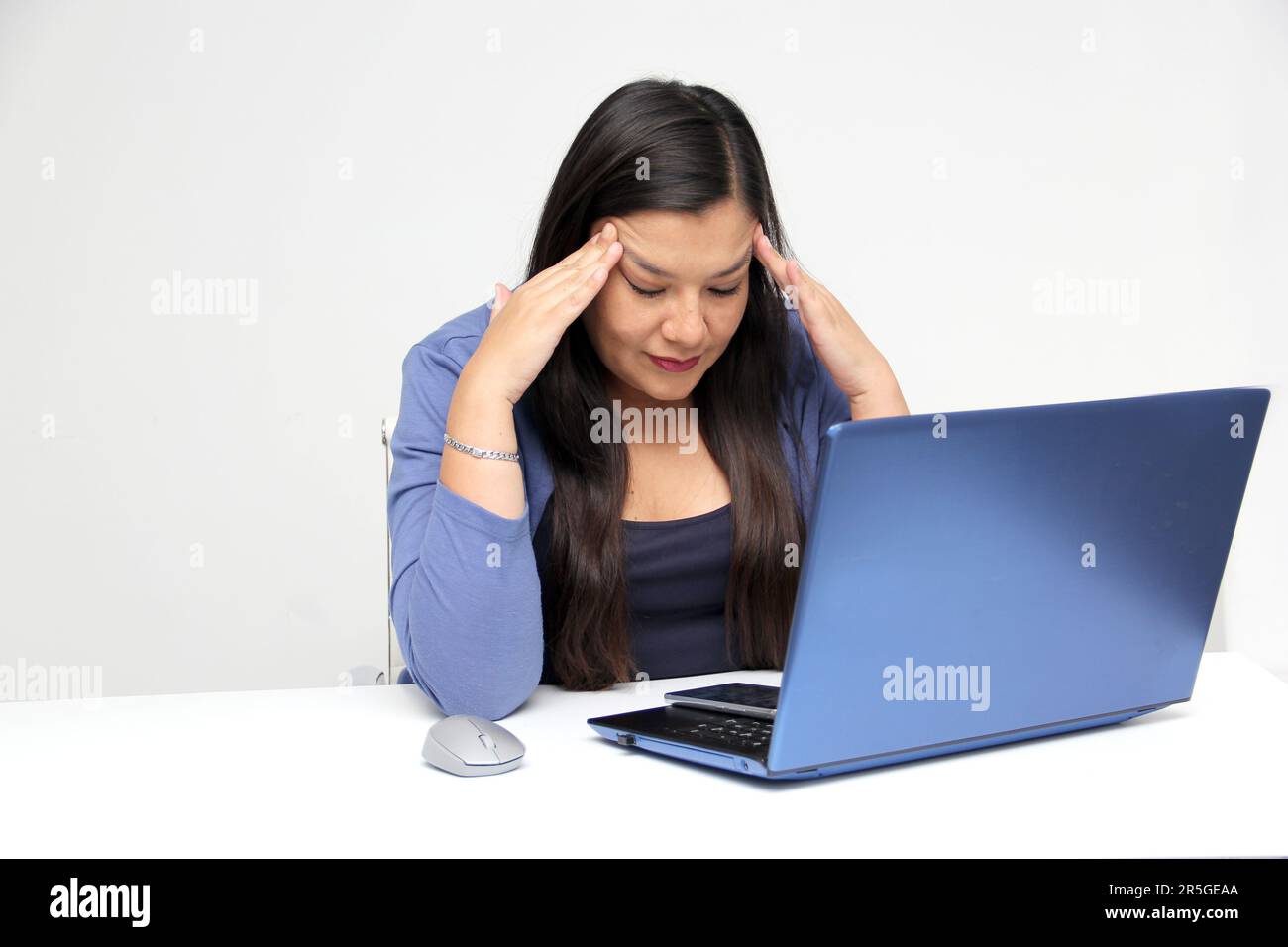 Dark-haired latin adult woman works in her office with laptop with a ...