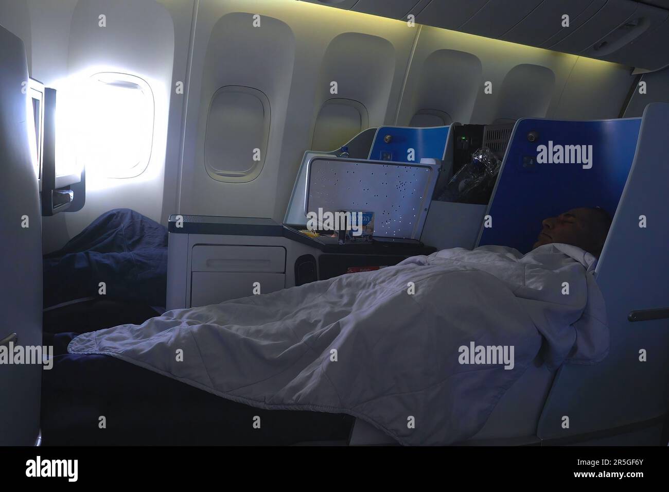 A passenger sleeps during flight at the Business class cabin of Boeing