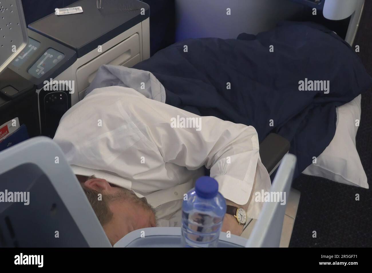 A passenger sleeps during flight at the Business class cabin of Boeing