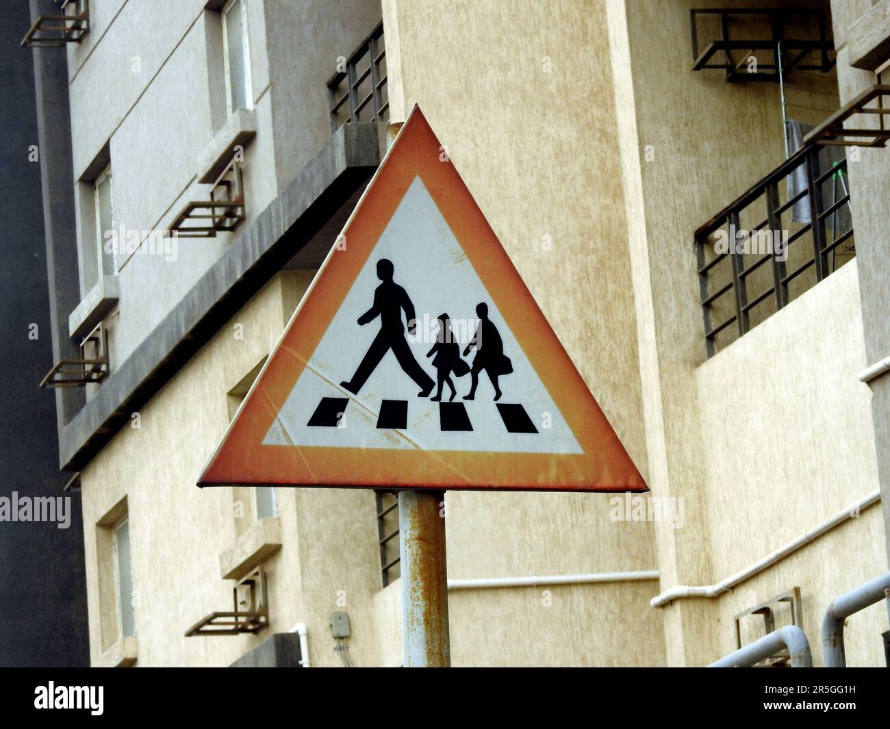 A school crossing sign at the side of the road to inform drivers to be alert of children crossing the street, school children warning crossing road si Stock Photo