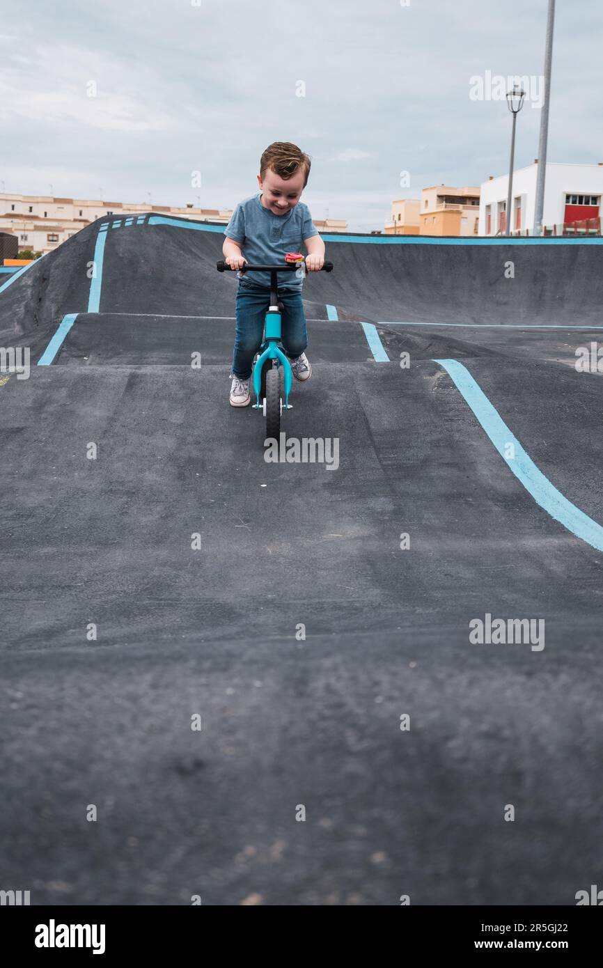 A young child rides the new South Glenmore Park BMX pump track on his