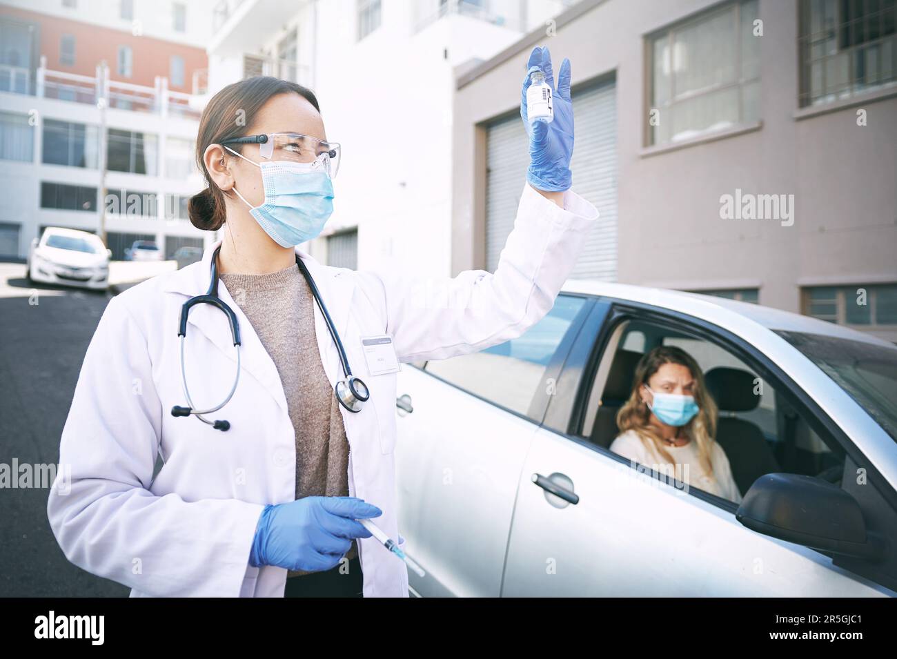 Pull up and be a part of the vaccine program. a masked young doctor ...