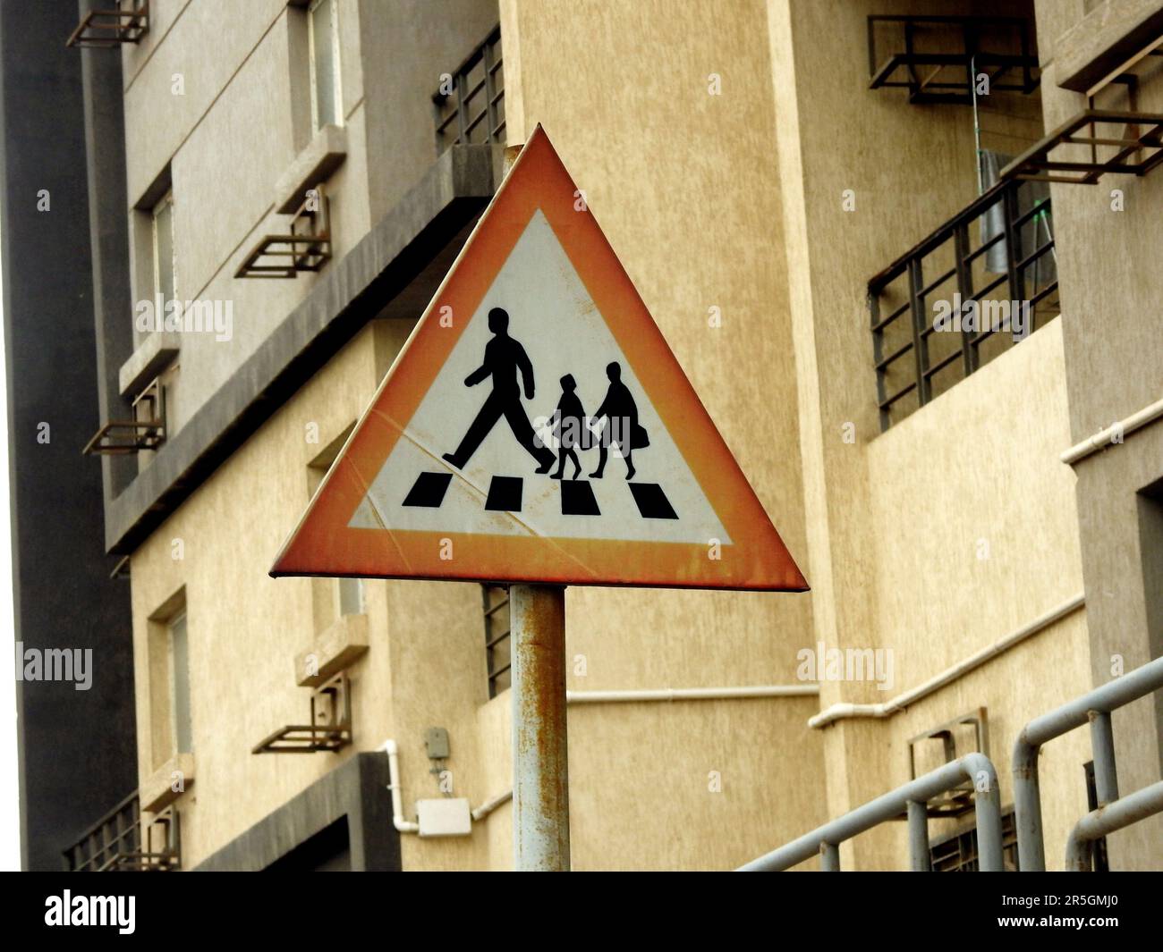 A school crossing sign at the side of the road to inform drivers to be alert of children crossing the street, school children warning crossing road si Stock Photo