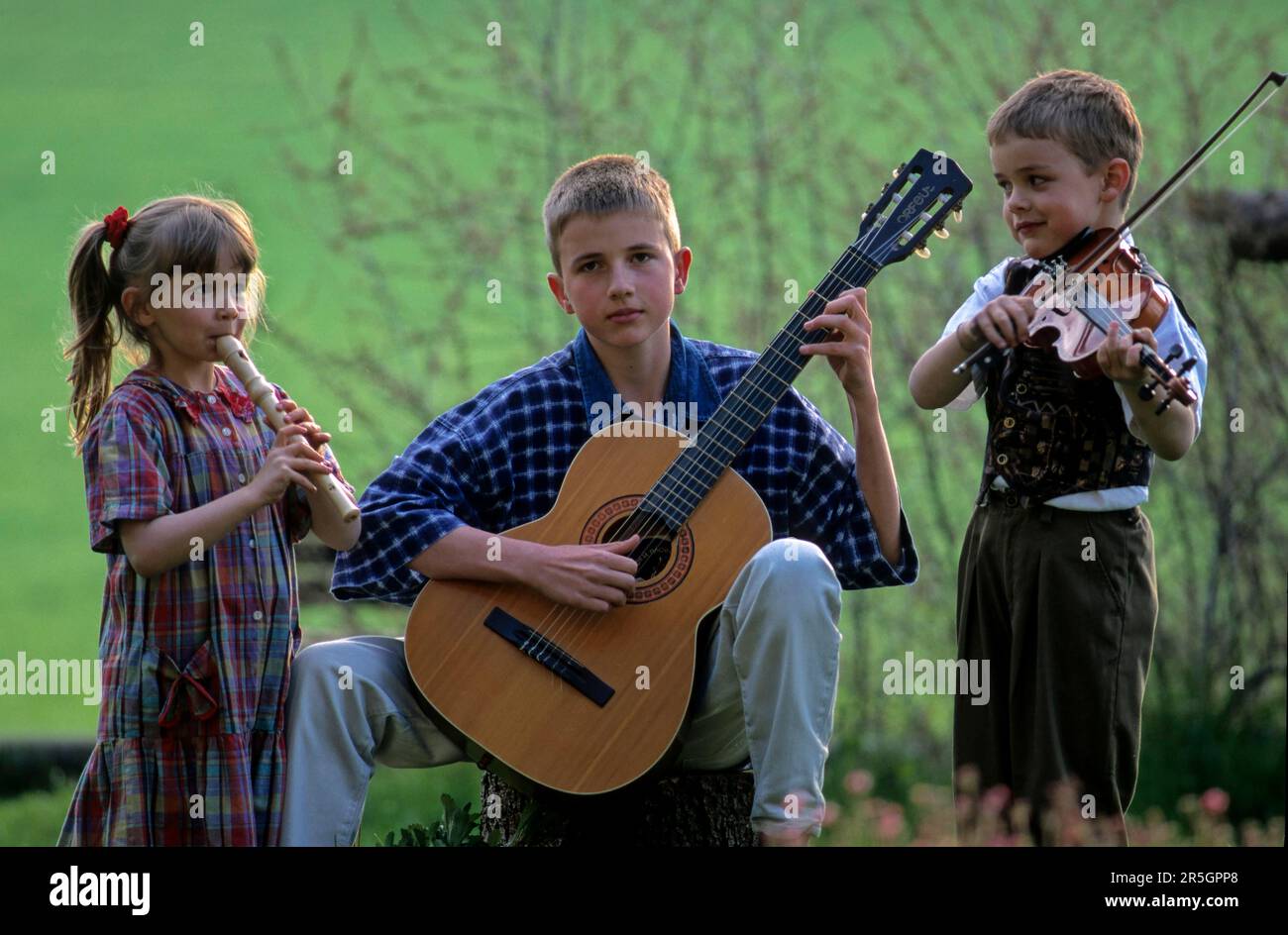 Children play the flute, guitar and violin Stock Photo