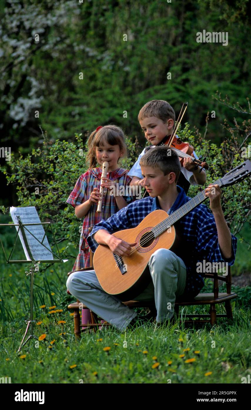 Children play the flute, guitar and violin Stock Photo