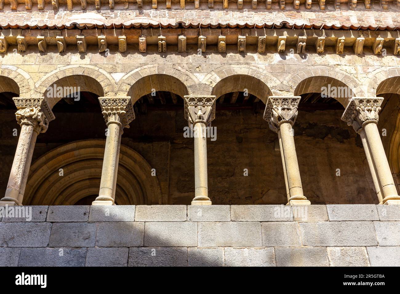 Porticoed gallery of the Iglesia de San Martín (Church of Saint Martin) in Segovia, Spain with semicircular arches with Romanesque capitals, Stock Photo