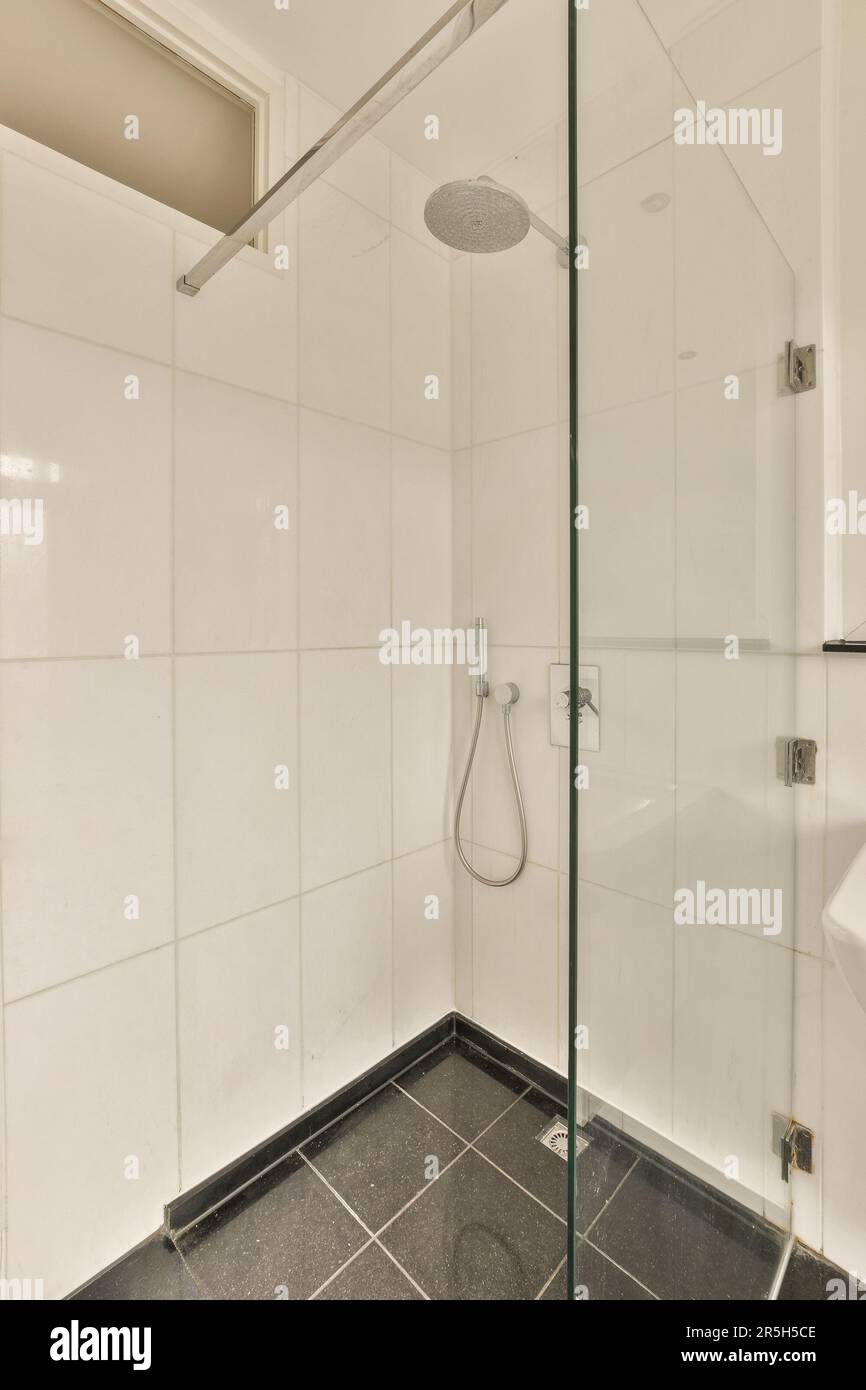 a modern bathroom with black and white tiles on the floor, glass shower ...