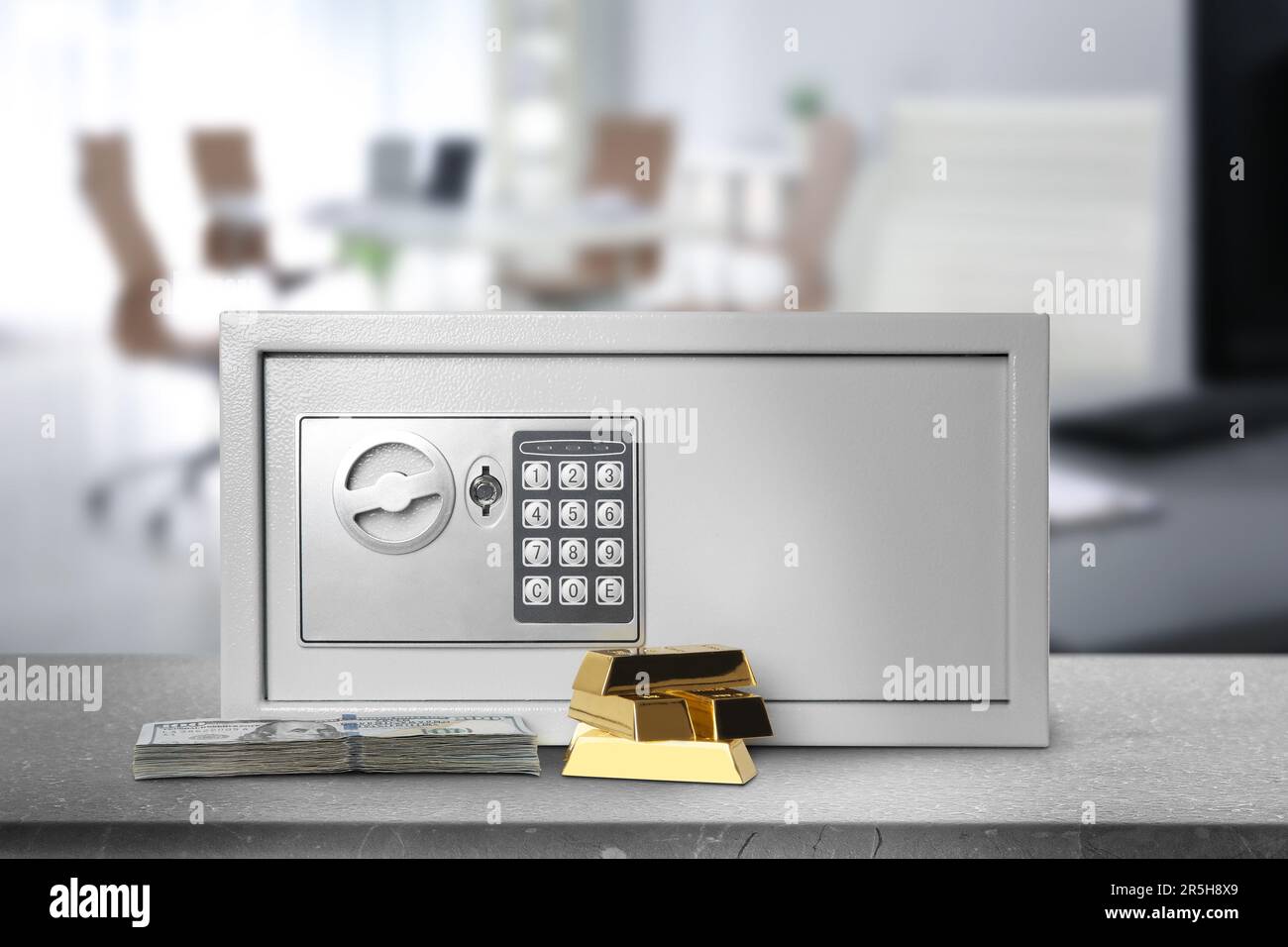 Closed steel safe with electronic lock, money and gold bars on grey