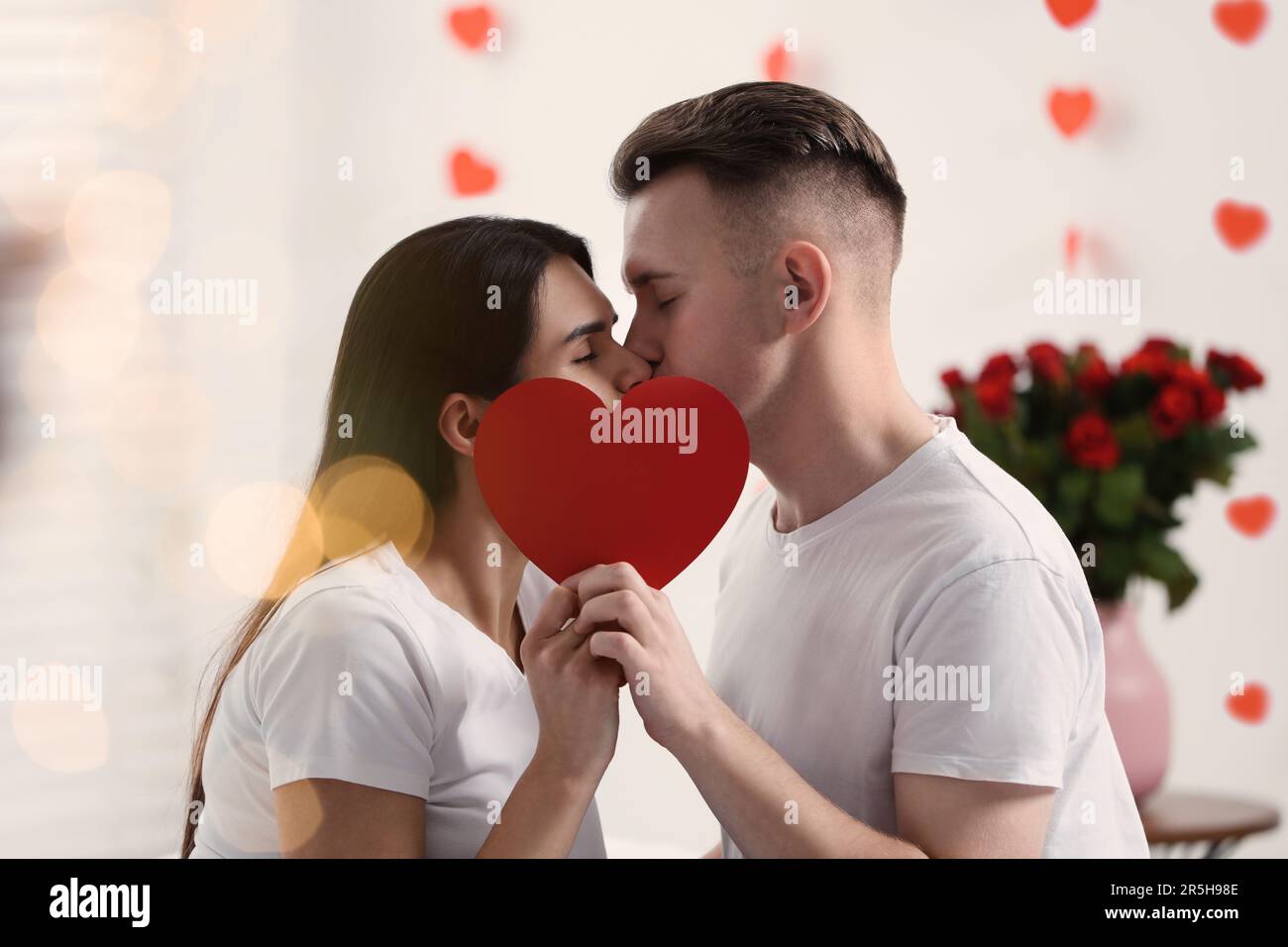 Couple kissing behind heart shaped hi-res stock photography and images ...
