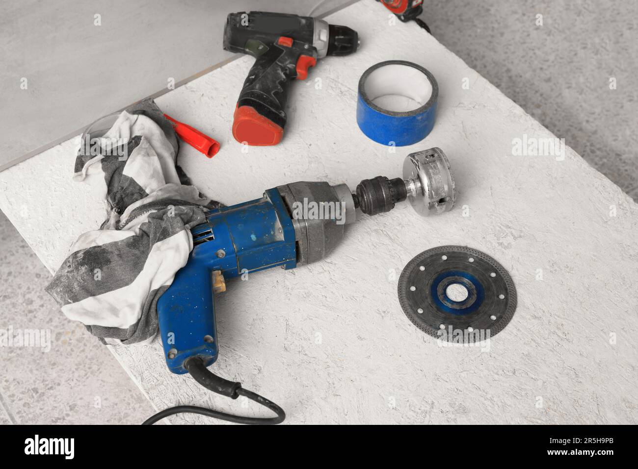 Buffing attachment drill and other equipment on chipboard indoors