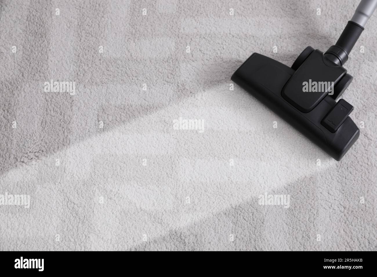 Vacuuming carpet. Clean area after using device, closeup Stock Photo