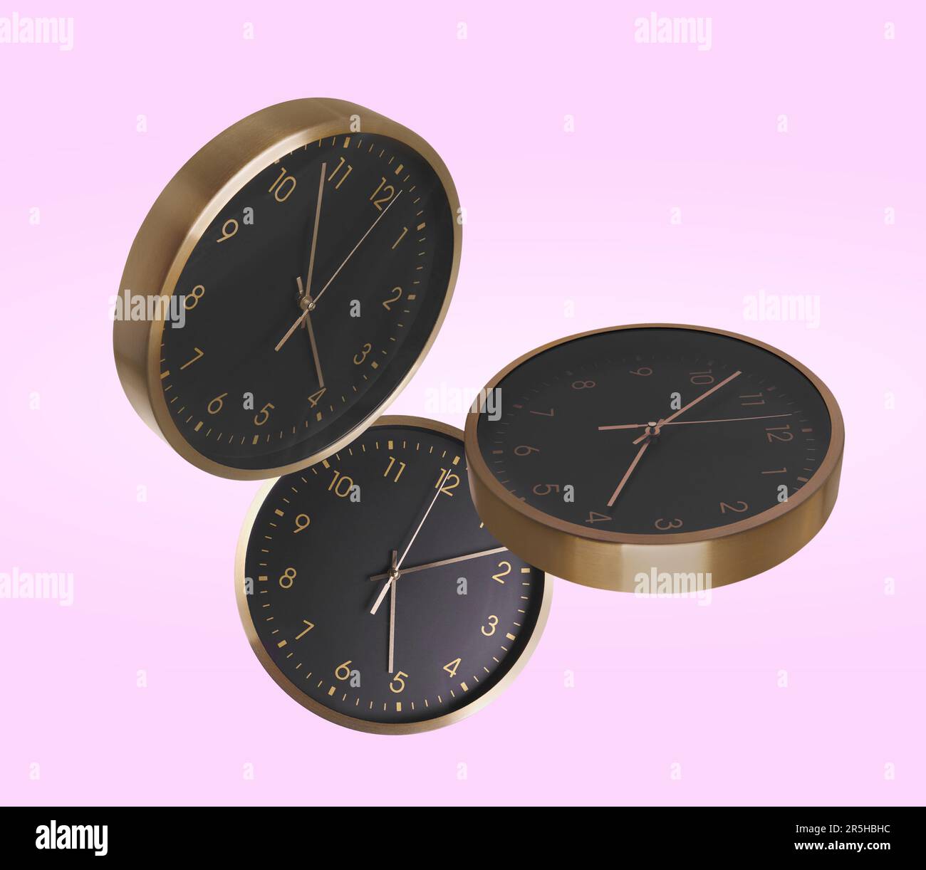 Stylish classic clocks falling on pink background Stock Photo Alamy