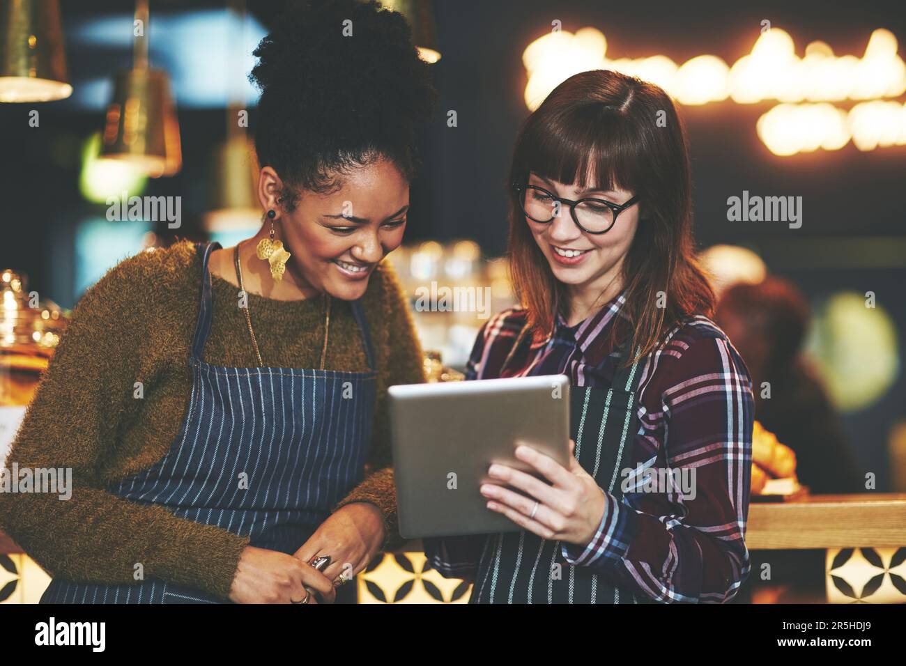 Their cafes menu is an interactive one. two young women using a digital