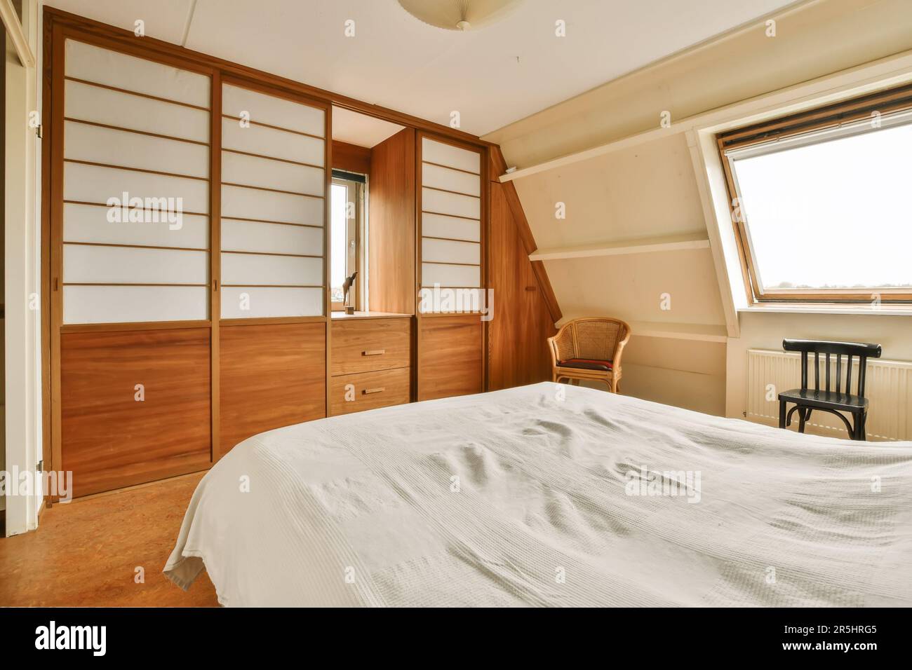 a bedroom with a bed, dresser and window in the corner to the left is ...