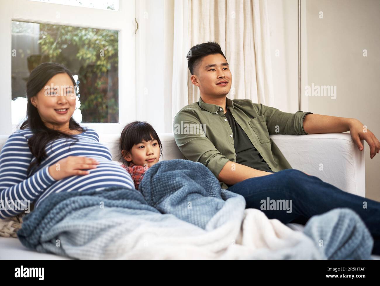 Movie night with the whole family. a family watching television together at home. Stock Photo