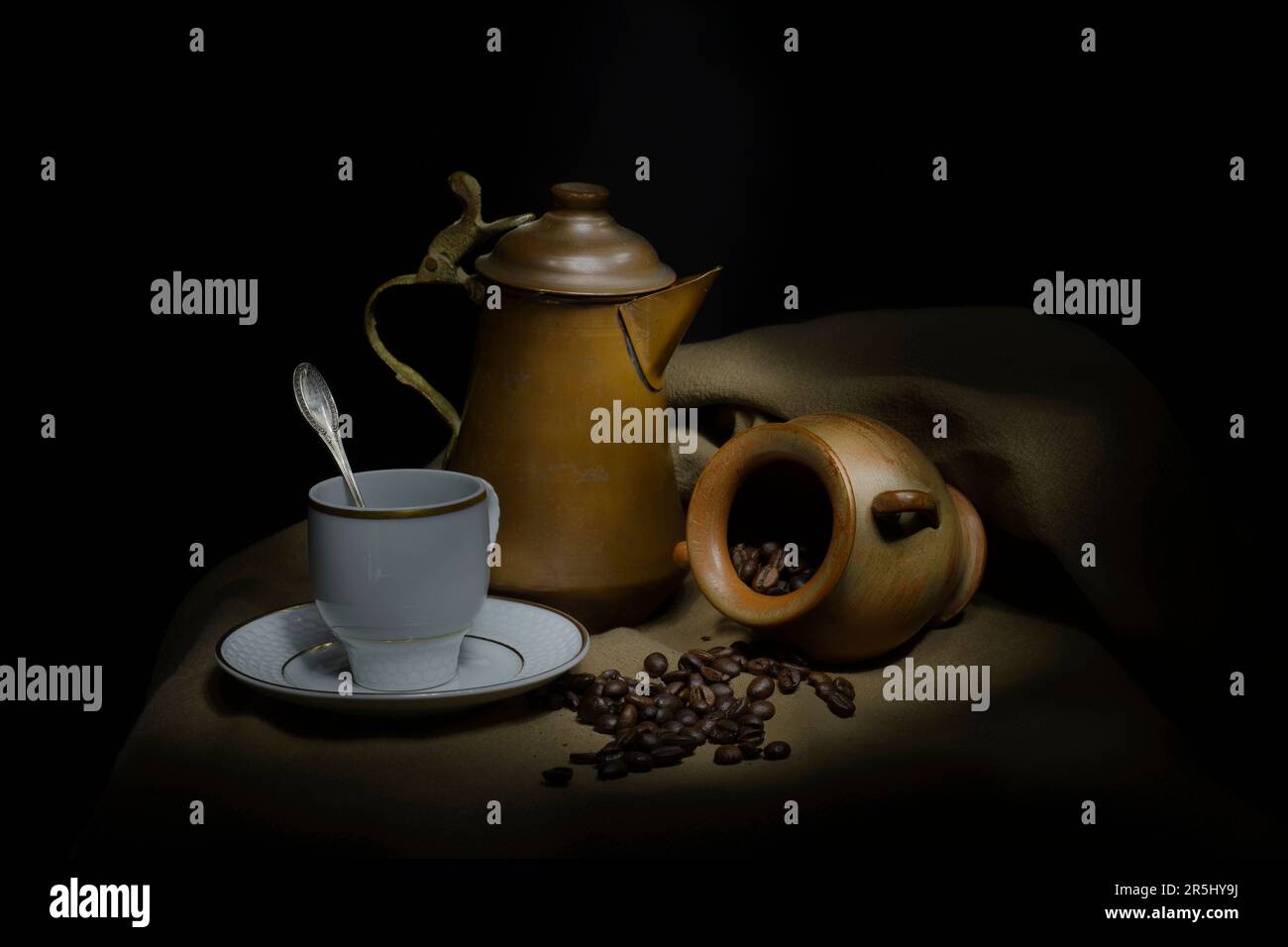 dark background with coffee beans with terracotta pot and copper pot Stock Photo