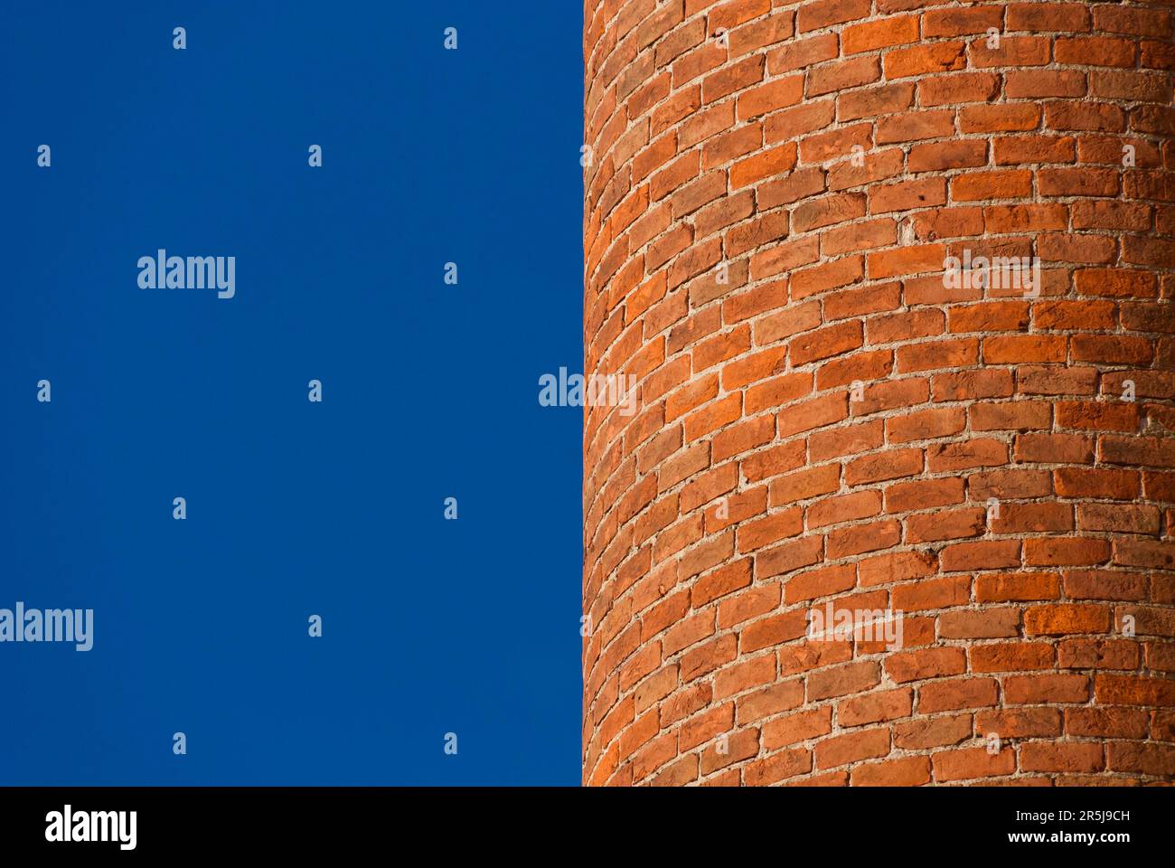 Curved brick wall with blue sky as background (with copy space) Stock Photo