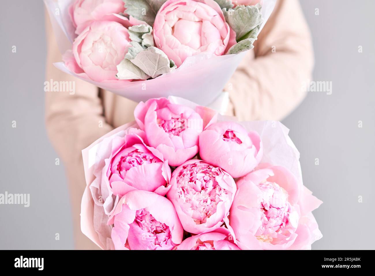 A bouquet of pink peonies in women's hands. Flower delivery. A ...