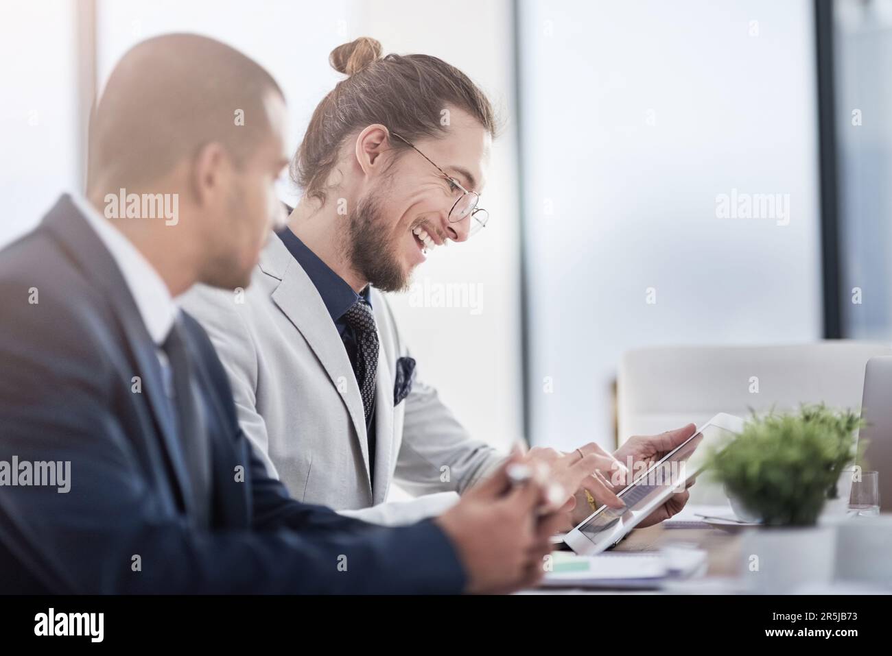 Smart entrepreneurs use smart technology. two young businessmen using a digital tablet together at work. Stock Photo