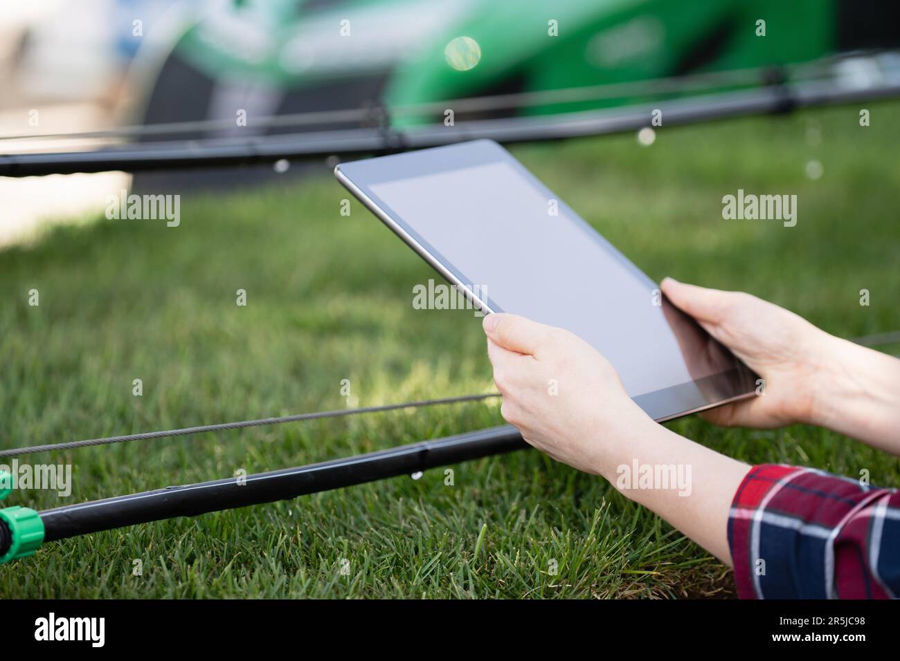 Farmer controls drip irrigation system with digital tablet Stock Photo